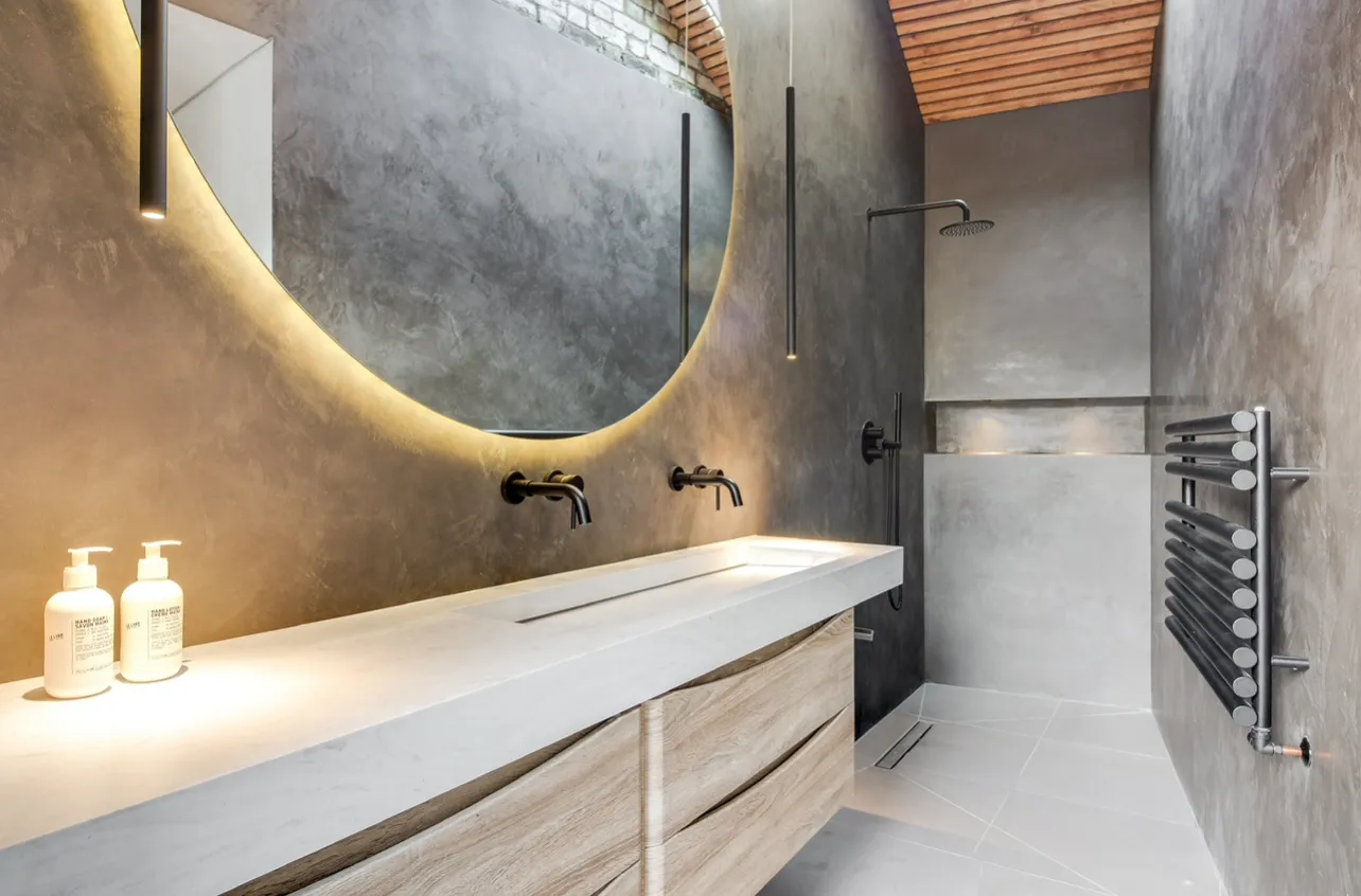 Photo of bathroom with marble walls and gold tap
