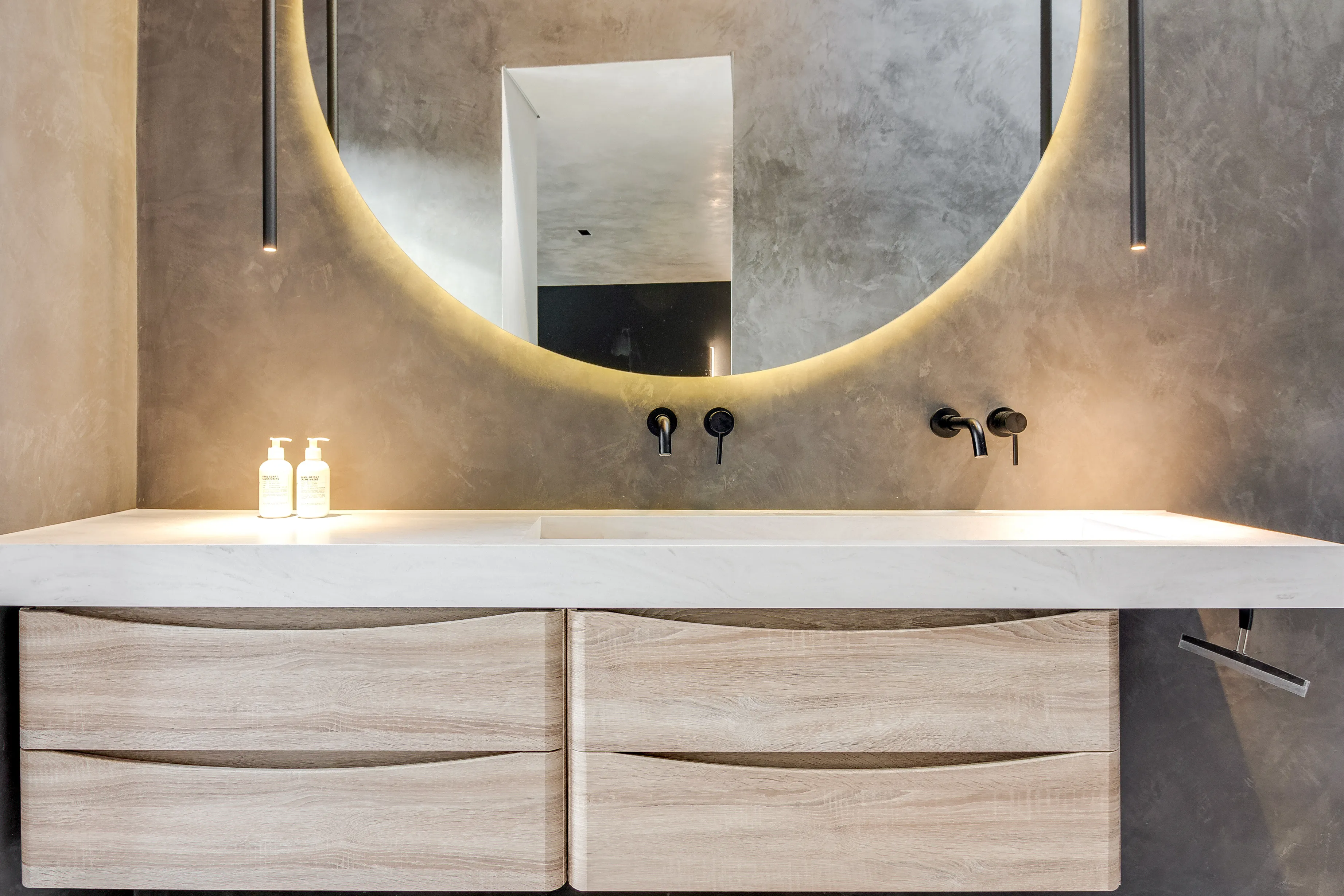 Photo of bathroom with marble walls and gold tap