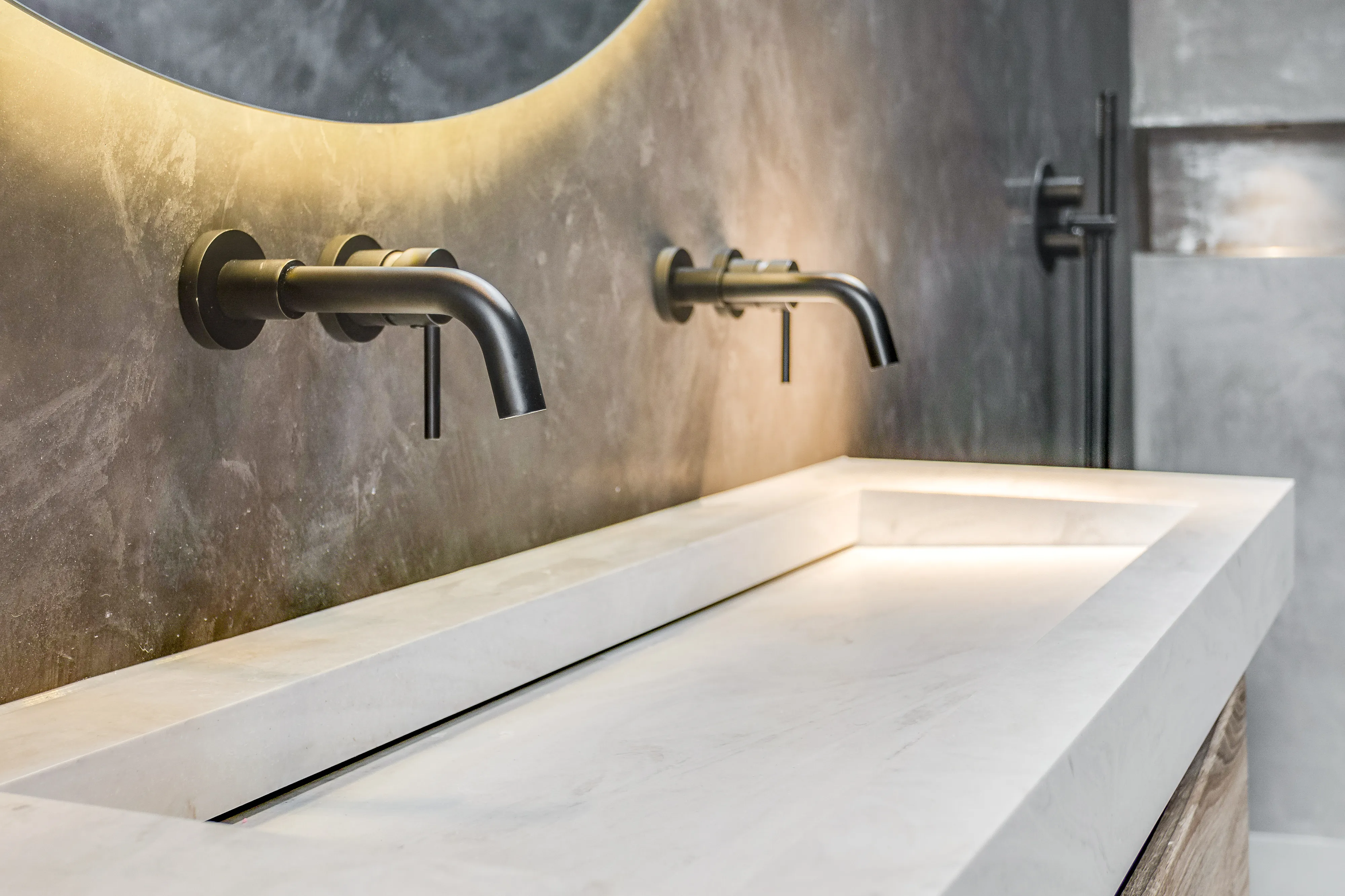 Photo of bathroom with marble walls and gold tap