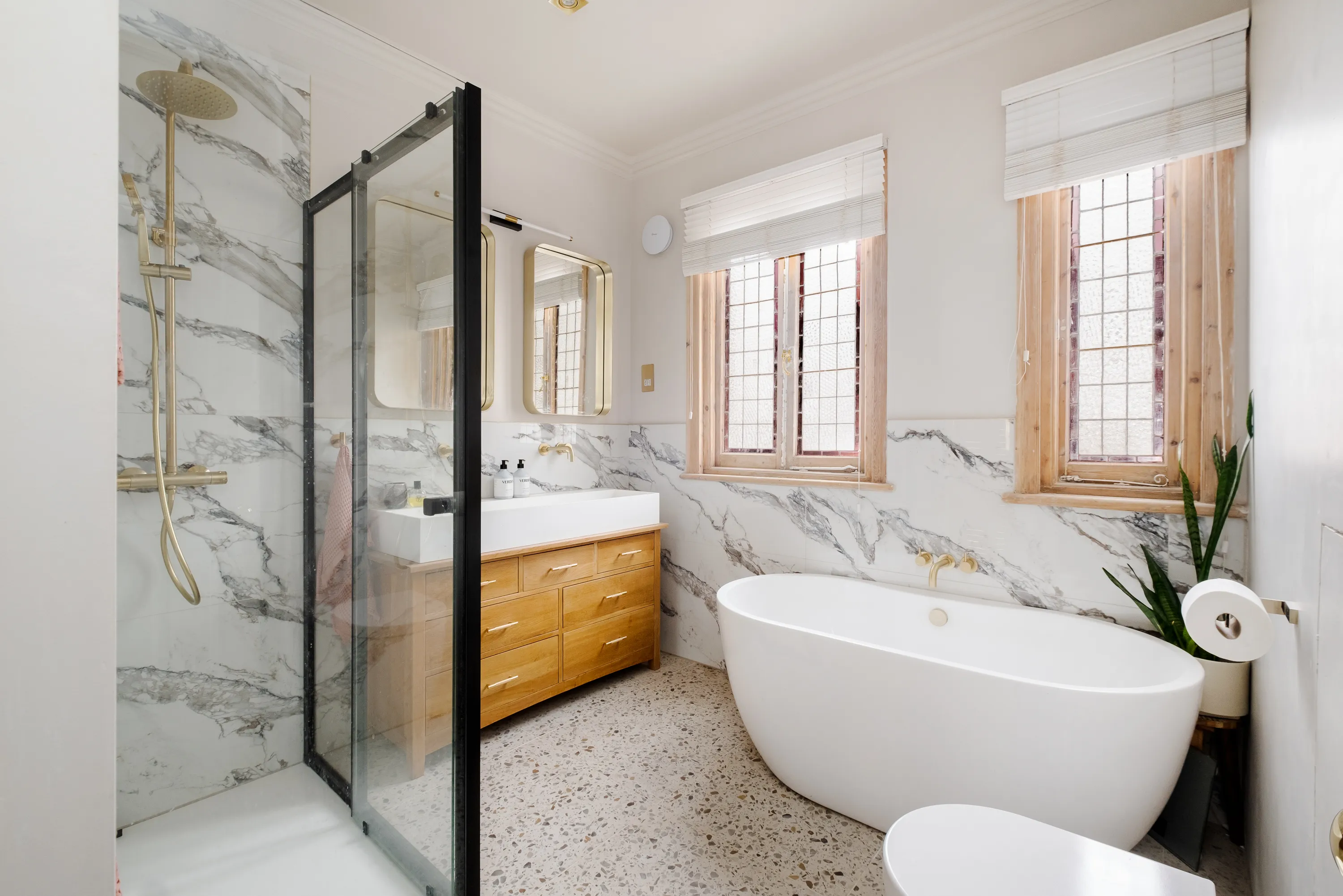 Photo of kitchen with marble worktop and gold tap