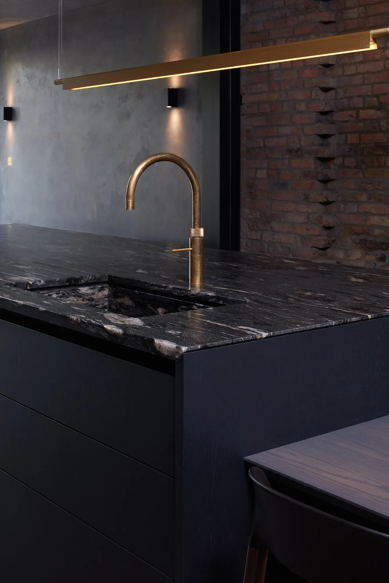 Photo of kitchen with marble worktop and gold tap