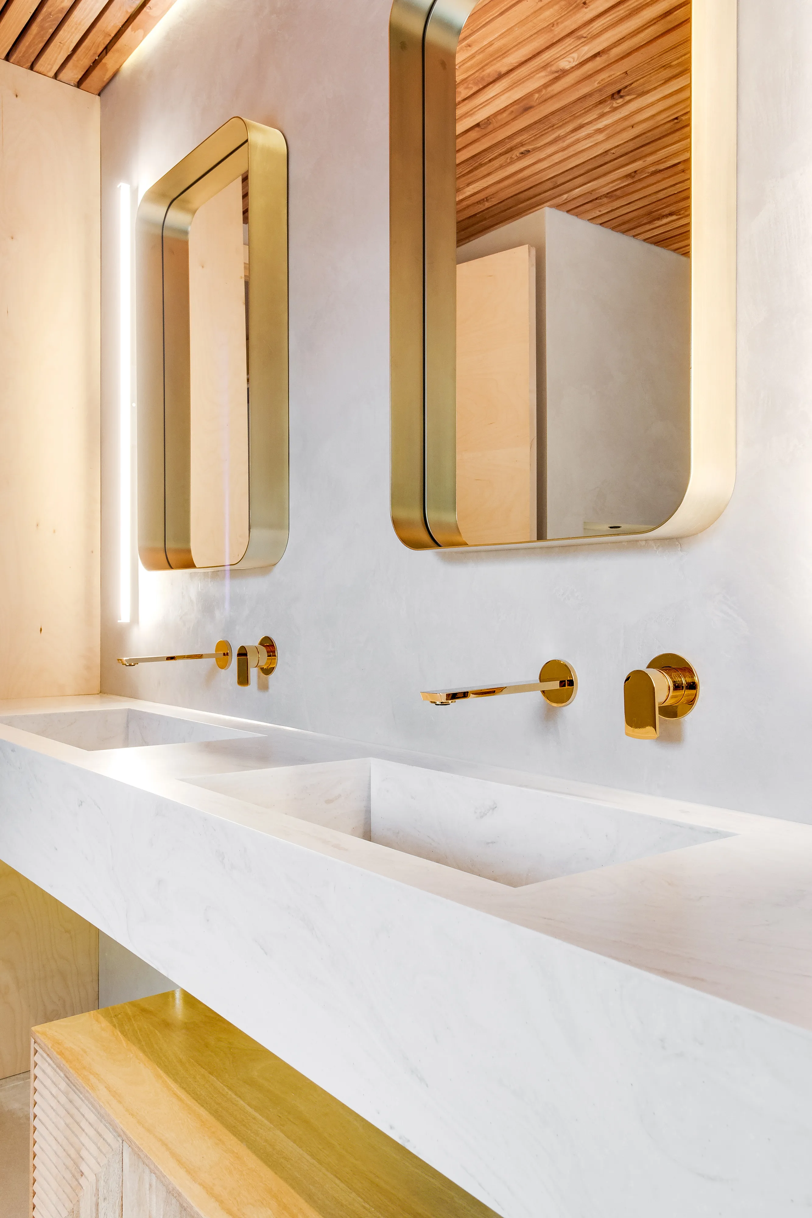Photo of bathroom with marble walls and gold tap