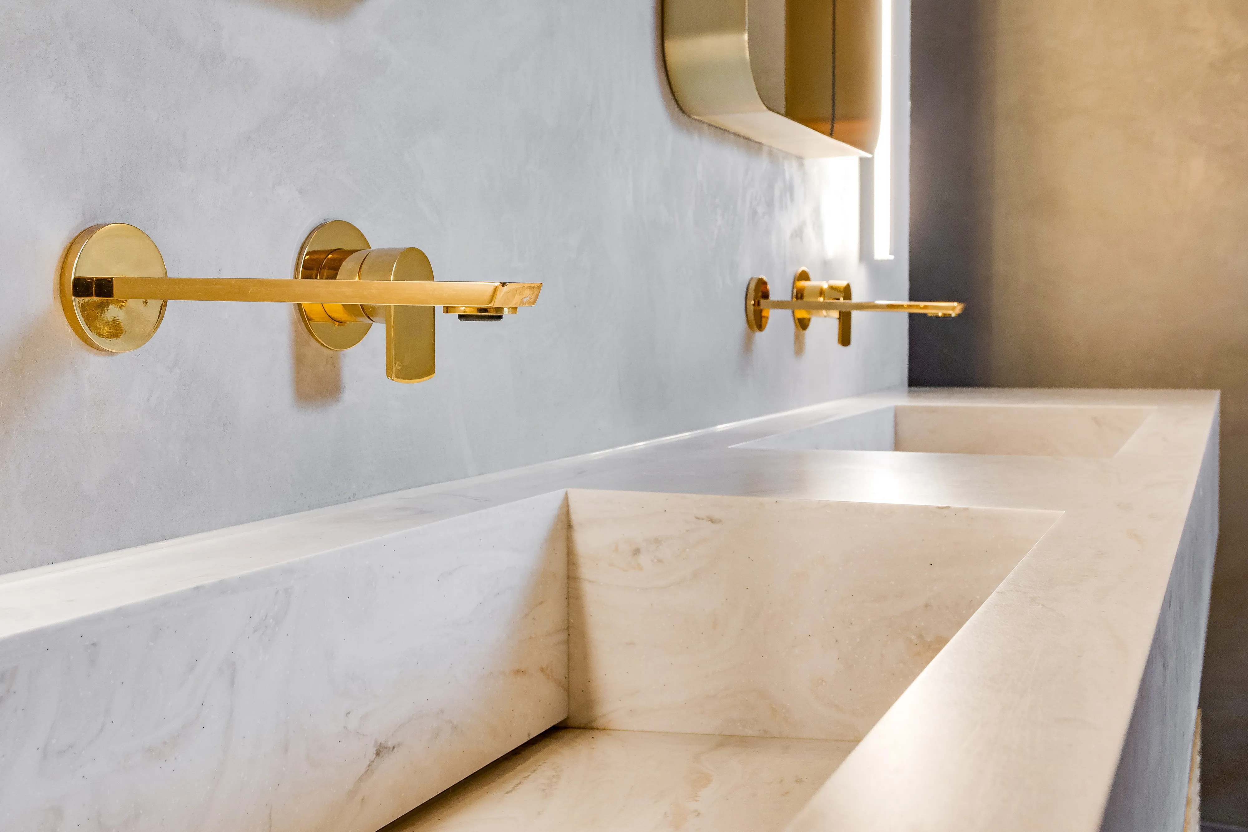 Photo of bathroom with marble walls and gold tap