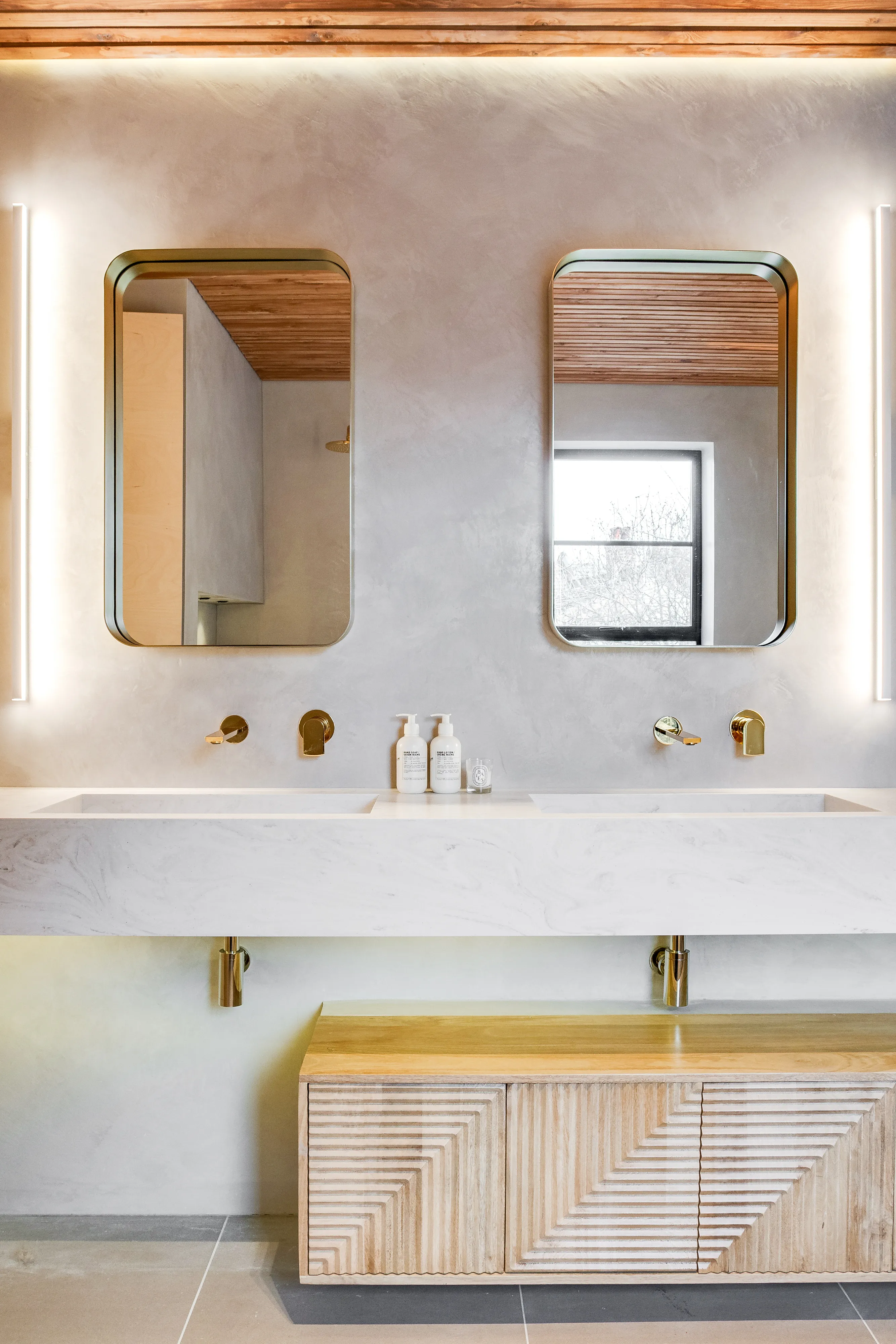 Photo of bathroom with marble walls and gold tap